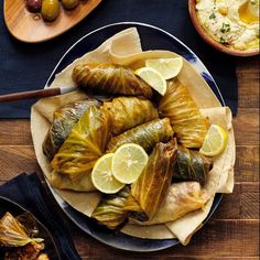 an assortment of food on a plate with lemons and olives next to it