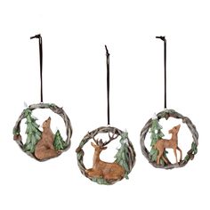 three ornaments with deer and pine trees on them