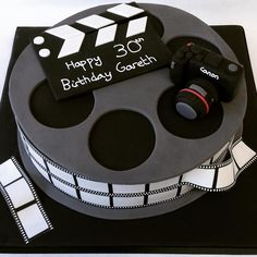 a birthday cake made to look like a film reel with camera and clapsticks