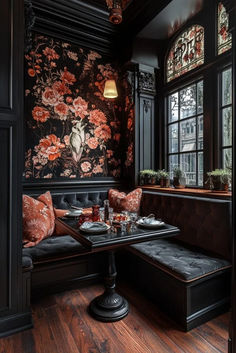 an elegant dining room with black walls and floral wallpaper on the walls, along with wooden flooring