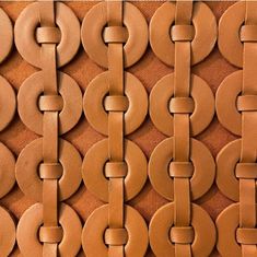 a close up view of a wall made out of circles and rings on brown leather