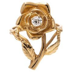 14k yellow gold ring. This charming ring is a figural rose motif, set in the center with a round brilliant cut diamonds, approximately 0.14 CTS, prong set. The ring is decorated with open rope patterned split shoulders. Marks: None, tested 14k Dimensions: 9/16" across the top x 7/8" long Weight: 2.8 gross dwt Rose Motif, Rose Ring, Lorde, Yellow Gold Ring, Round Brilliant Cut Diamond, Brilliant Cut Diamond, Yellow Gold Rings, Figurative, Round Brilliant