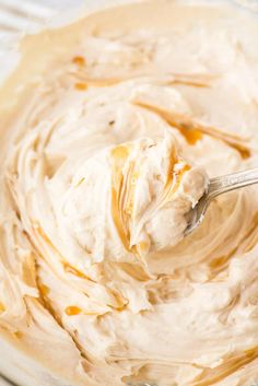 a spoon in a bowl filled with cream