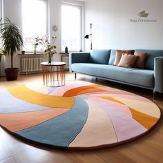 a living room filled with furniture and a rug on top of a hard wood floor