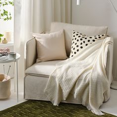 a living room with a couch, chair and table covered in a polka dot blanket