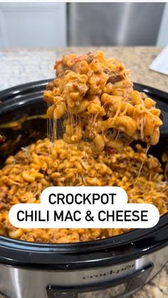 the crockpot chili mac and cheese is being lifted from the slow cooker