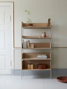 a book shelf with books and other items on it in front of a white door