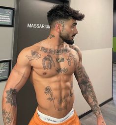 a shirtless man with tattoos on his chest