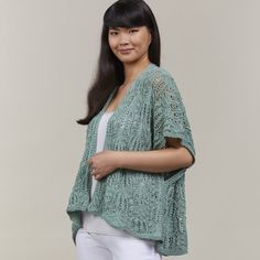 a woman in white pants and a green cardigan