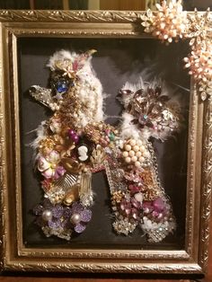 a framed photo with an animal made out of beads and other things in it's frame