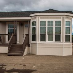 a mobile home with stairs leading up to the front door and steps down to the second floor