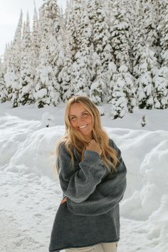 a woman standing in the snow with her arms crossed