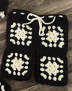 two crocheted black and white items on wooden floor