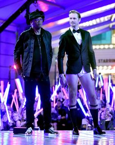 two men in tuxedos are walking on the runway