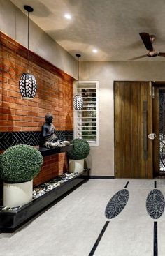 a room that has some plants on the floor in front of it and two buddha statues