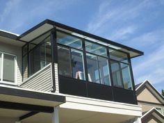 a house with a balcony and glass balconies