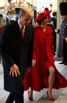 the man and woman are dressed in red for an official event, as well as other people