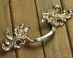 an ornate silver ring sitting on top of a wooden table