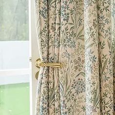 an open window with curtains in front of it and a curtain rod on the side