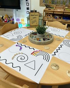 a wooden table topped with a potted plant and lots of different colored beads on top of it