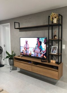 a flat screen tv sitting on top of a wooden entertainment center in a living room