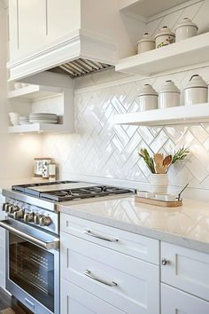 a white kitchen with an oven, stove and cabinets in it's center island