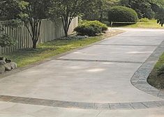 a man riding a skateboard down a sidewalk next to a lush green park filled with trees