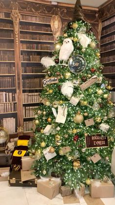 a christmas tree is decorated with many books and ornaments, including an owl ornament