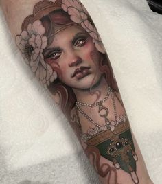 a woman's face with flowers and chains on her arm is shown in this tattoo design