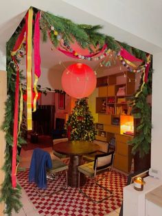 a room decorated for christmas with decorations on the ceiling and table in front of it