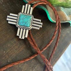 This awesome bolo tie has a southwestern cross design and agate stone centerpiece.Our bolos pair nicely with many of our belt buckles! They make wonderful gifts.The western bolo tie rope length is 100cm (39") and the pendant is 1 3/4'' wide Southwestern Bolo Tie With Adjustable Lariat Cord, Southwestern Style Lariat Bolo Tie With Adjustable Cord, Bohemian Concho Bolo Ties For Rodeo, Southwestern Style Adjustable Lariat Bolo Tie, Bohemian Bolo Tie With Concho, Southwestern Turquoise Bolo Ties For Western-themed Events, Southwestern Turquoise Bolo Tie For Western-themed Events, Southwestern Bolo Ties With Concho, Southwestern Lariat Bolo Ties For Ranch