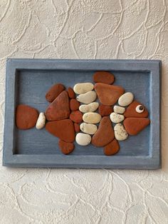 a blue tray with rocks in the shape of fish and other small stones on it