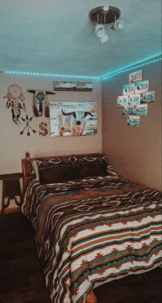 a bed room with a neatly made bed and pictures on the wall next to it