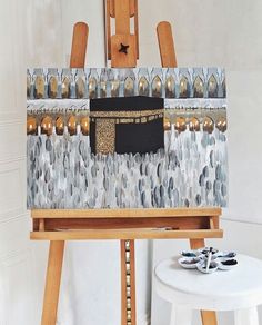 an easel with a painting on it in front of a wall