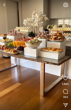 a table filled with lots of food on top of a hard wood floored floor