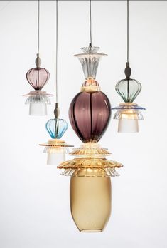 an assortment of different colored glass lamps hanging from strings