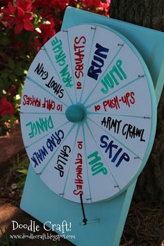 a blue and white clock sitting next to a tree with writing on the front of it