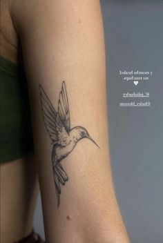 a small hummingbird tattoo on the right side of the left arm, with words above it