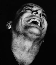 a black and white photo of a man with his mouth open