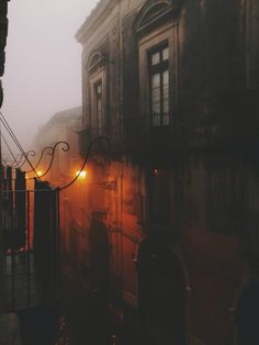 a foggy street with an old building in the background