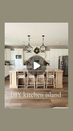 the kitchen island is surrounded by white cabinets and wood flooring, with chandeliers hanging from the ceiling