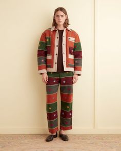 These trousers are inspired by a 1920s-1940s quilt. It features a faithful reproduction of a bar-style quilt made from wool suiting fabric. The quilt is embroidered with a feather stitch along the edges of each patch and flowers with a knotted center.  The silhouette is that of a traditional trouser — high rise, straig Autumn Quilt, Feather Stitch, Suiting Fabric, Fall Quilts, Bar Styling, Mens Trousers, Trouser Pants, Quilt Making, High Rise