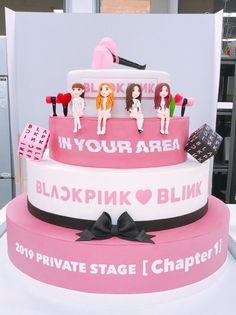 a pink and white cake with barbie dolls on top