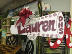 a sign that says lauren phs hanging from the side of a wall next to a table