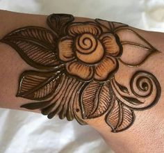 a woman's arm is decorated with hennap and flower designs on it