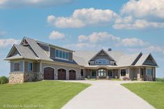 a large house with lots of windows on the front and side of it, surrounded by lush green grass