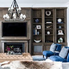 a living room filled with furniture and a flat screen tv mounted on a wall next to a fire place