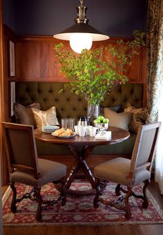 a dining room table with two chairs and a potted plant on top of it