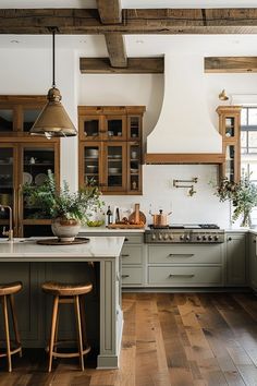 a large kitchen with wooden floors and white walls, along with green cabinetry that matches the wood flooring