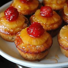 small pineapples with cherries and jelly on top are sitting on a white plate